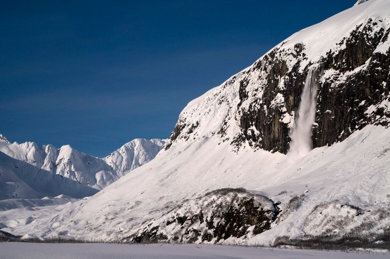Avalanche over Cliffs, Kenai Fjords, Alaska. Spring sun released south-facing slopes above steep cliffs, sending avalanches to the valley floor. Northwestern Fjord, Kenai Fjords National Park.
